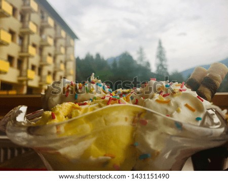 Sweet colorful ice cream with candies, mountains in background