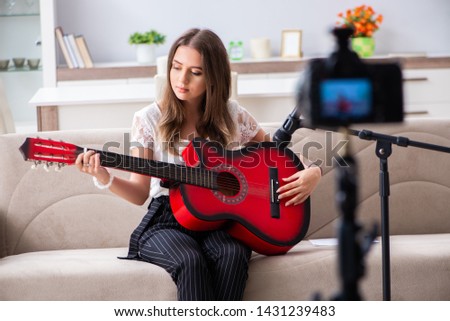 Female beautiful blogger playing guitar 