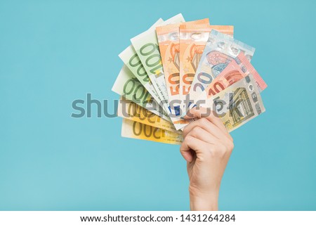 Female hands holding euro banknotes on a blue background. Euro Money. euro cash background Royalty-Free Stock Photo #1431264284