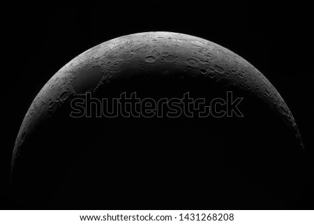 Crescent of a young moon with a large increase. Moon, view through a telescope. The moon with craters. Real photos of space objects through a telescope. Natural background.
