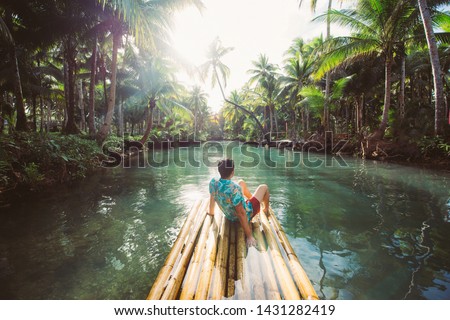 Palm tree jungle in the philippines. concept about wanderlust tropical travels. swinging on the river. People having fun Royalty-Free Stock Photo #1431282419