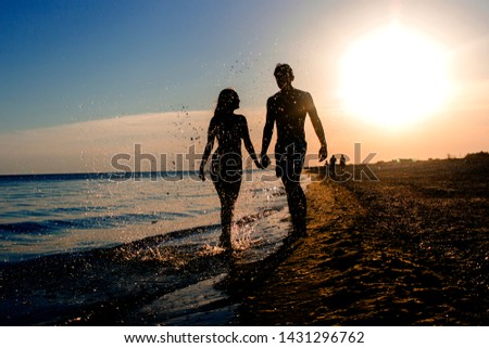 couple in love boy and girl go on the beach sea sunset silhouettes summer