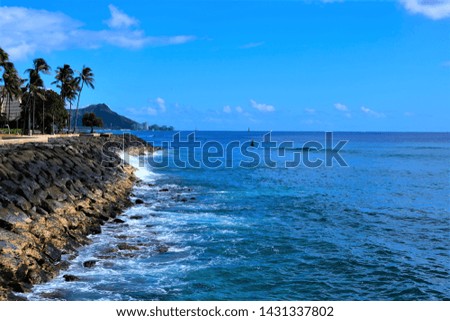 Honolulu Oahu Waikiki coastline to include views of Diamond Head, Waikiki beach, various hotels and waves rolling on to shore.