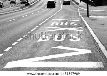 Road surface markings at bus stop on city street  in black and white high contrast