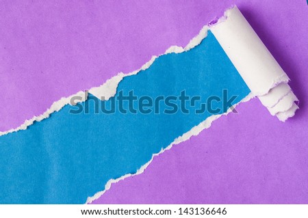 Recycled purple paper torn on blue background.
