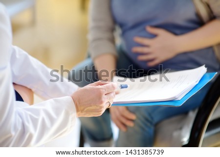 Pregnant woman sign the contract or permit during accepts of gynecologist doctor. Medical insurance childbearing. Family doctor for gestation. Maternity leave. Health care and medicine.