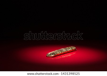 Bitcoins Highlighted with a Spotlight on a Red Reflective Background. Bear Market, drop, dump for Crypto Currency. Digital Assets blockchain stocks loss, down trend. Royalty-Free Stock Photo #1431398525