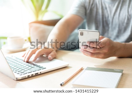 hand holding using texting cell phone and typing computer.businessman at workplace Thinking investment plan.chatting contact Investor.searching for information use internet.connecting people concept