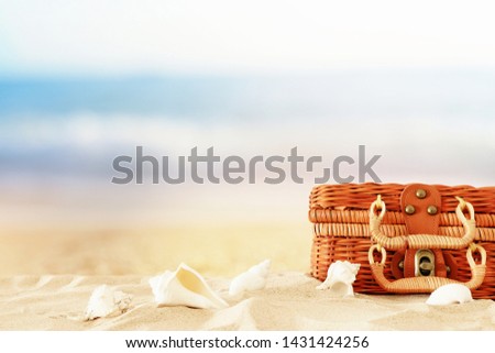 holidays. Beach straw suitcase and wooden boat in the sand. Tropical summer vacation concept