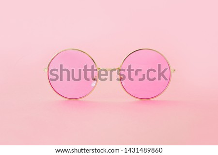 Round hipster sunglasses with pink lenses and golden frame. Fashion accessory for women