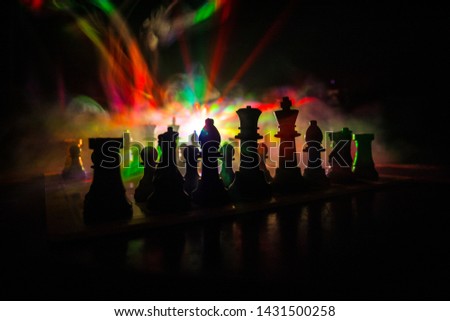 Chess board game concept of business ideas and competition. Chess figures on a dark background with smoke and fog. Selective focus