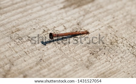 Rusty nail in old wood from above