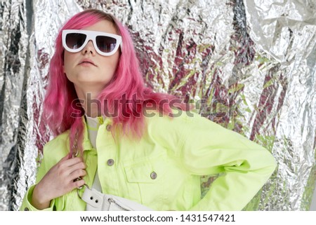foil background woman serious in glasses with pink hair