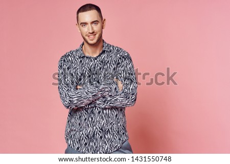 A man in a zebra shirt on a pink background cropped view of his arms across his chest                      