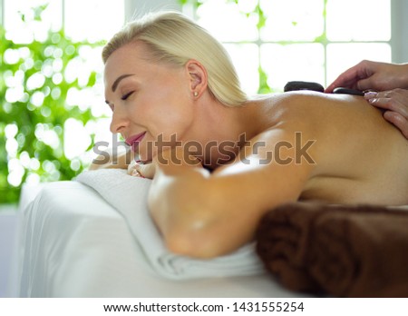 Beautiful young woman relaxing during full body massage at spa