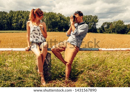 Photographer taking picture of a beautiful woman in a countryside landscape