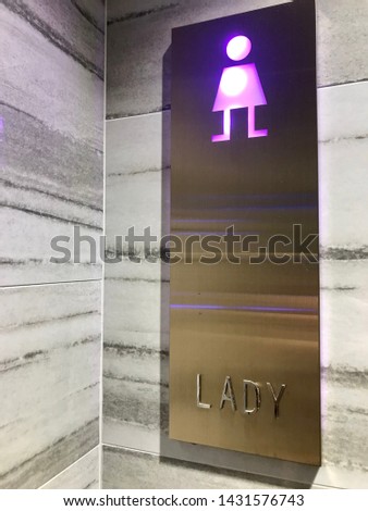 Sign of LADY for the restroom or toilet on white marble wall