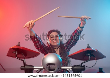 Music and hobby concept - woman drummer playing the electronic drum set