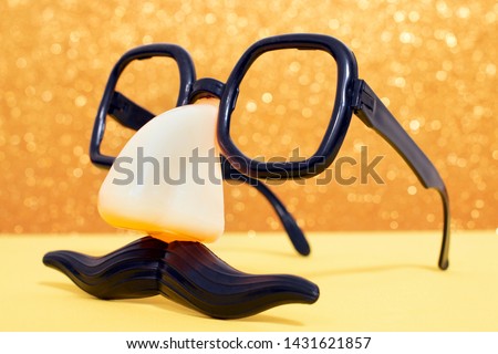 disguise masquerade glasses isolated on a golden background.