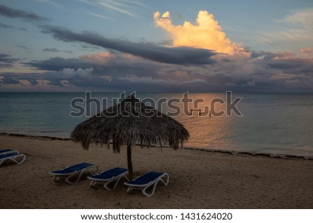 Beautiful view of a sandy beach, Playa Ancon, on the Caribbean Sea in Triniday, Cuba, during a cloudy and rainy sunrise.