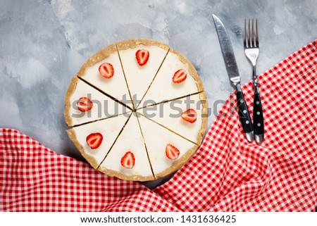 Homemade cheesecake with fresh strawberries sliced on concrete background