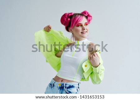 woman with pink hair is smiling on a light background