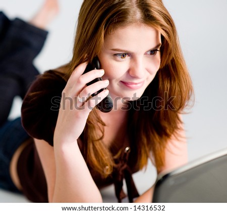 A young woman using laptop and mobile phone (shallow depth of field used)