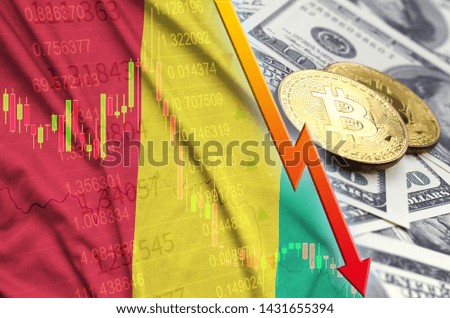 Guinea flag and cryptocurrency falling trend with two bitcoins on dollar bills