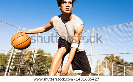 Athletic male playing basketball outdoors. Man dribbling the ball at the court. Royalty-Free Stock Photo #1431685427