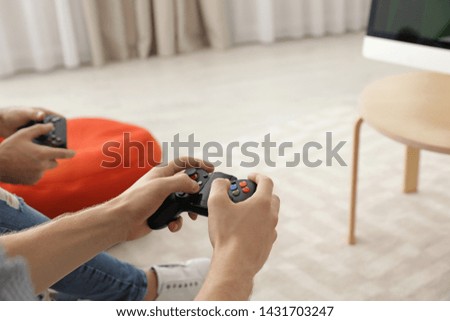 Friends playing video games at home, closeup view