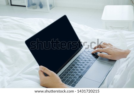 Beautiful Asian woman is smiling.Lady work with laptops on the sofa in the room in the morning.She is happy to get a new job, success, or get good news.Do not focus on the main object of this image.