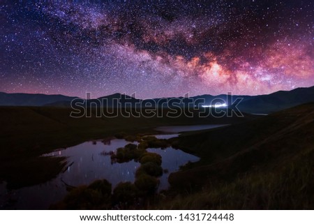 Beautiful starry night. Milky way galaxy over the lake with reflection and mountains. Night landscape