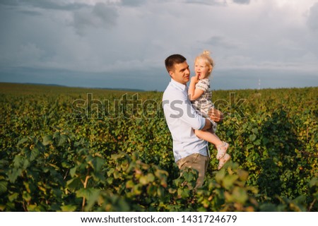 Portrait of cute little girl held in father's arms. Happy loving family. Father and his daughter child girl playing hugging. Cute baby and daddy. Concept of Father day. Family holiday and togetherness
