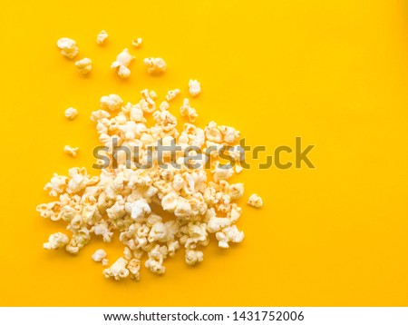 Popcorn on yellow background. Top view with copy space.