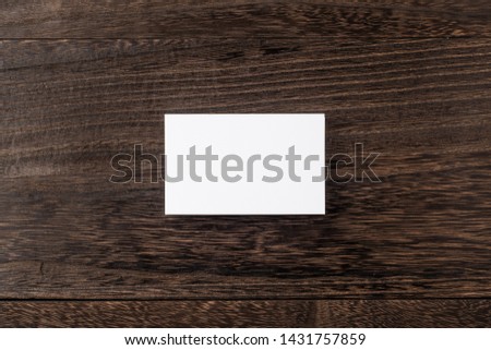 Design concept - top view of white business card on wood floor background for mockup