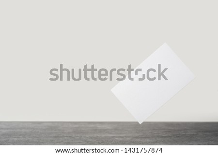 Design concept - front view of white business card on stone floor background for mockup