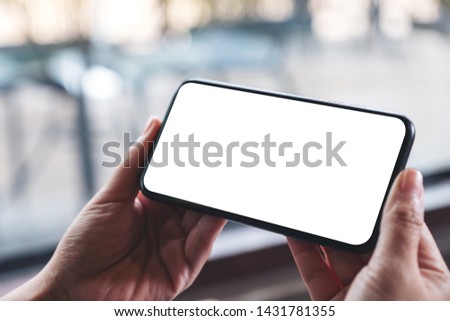 Mockup image of woman's hands holding black mobile phone with blank desktop screen