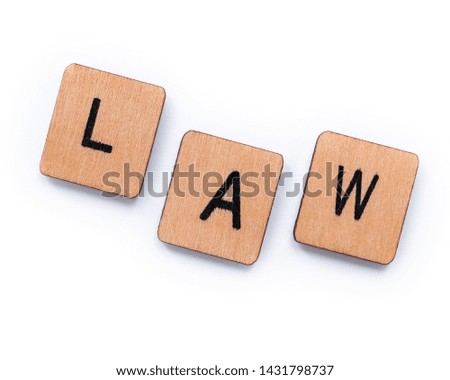 The word LAW, spelt with wooden letter tiles over a white background.