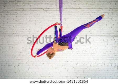 aerial gymnastics on the circle, a little girl doing exercises.
