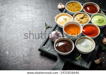 A variety of delicious sauces with slices of garlic. On dark rustic background Royalty-Free Stock Photo #1431856646