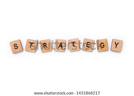 The word STRATEGY, spelt with wooden letter tiles over a white background.