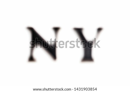 The inscription NY. New York in black blurred letters on a white background. Photo of the lettering