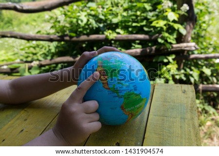sphere on the map of the world.someone shows America on the map. we teach children the world.