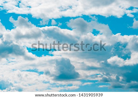 Air and fluffy clouds in the blue sky on a sunny day, background texture