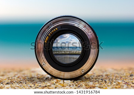 View of the sea surf through a photographic lens lying on a sandy beach on a sunny day. Royalty-Free Stock Photo #1431916784