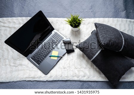 Laptop on white bed work at home concept. Background image.