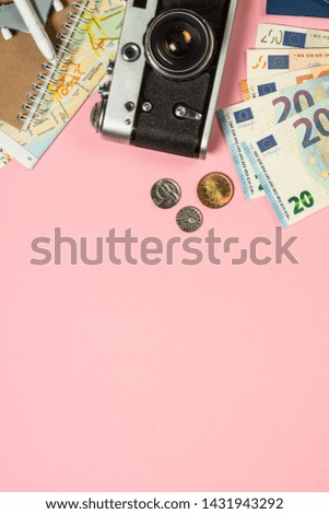 Travel Trip background flat lay. Old film camera, map and cash money on pink background.