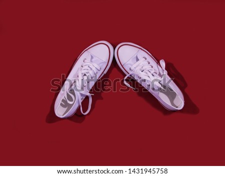 white shoes are in the form of a check mark on a red background with laces tied