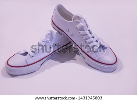 white sneakers on a white background, stand on each other in the middle for the entire size of the photo