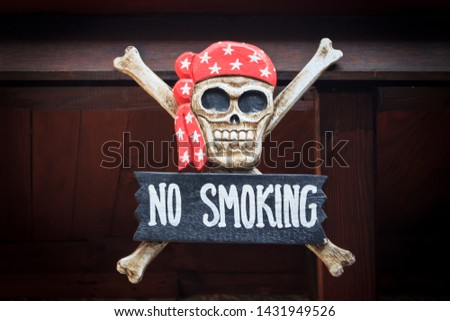 Wooden no smoking board with red hood skull and two bones